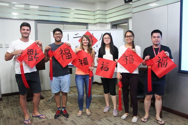 International students pose with their calligraphy charms 